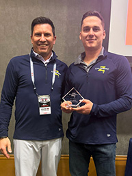 Two franchise professionals holding an award